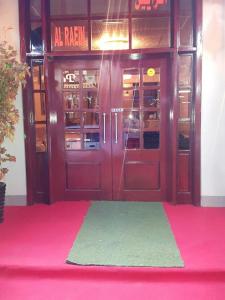 a pair of doors to a restaurant with a pink carpet at Holiday homes in Dubai
