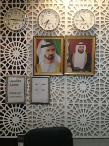 three clocks on a wall with pictures of prophets at Holiday homes in Dubai