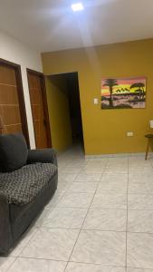 uma sala de estar com um sofá e uma parede amarela em Casa praia Serrambi em Porto de Galinhas