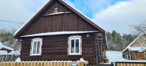 a small wooden house with snow on the roof at Skroblakówka 