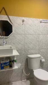 uma casa de banho com um WC, um lavatório e um espelho. em Casa praia Serrambi em Porto de Galinhas