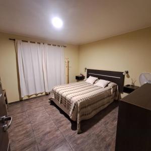 1 dormitorio con cama y ventana grande en LOS MELLIS en Villa Elisa