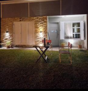 una mesa y dos sillas en un patio por la noche en LOS MELLIS en Villa Elisa