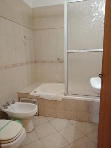 a bathroom with a tub and a toilet and a sink at Manantiales Hotel Boutique in Victoria