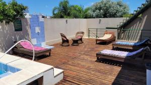 a deck with chairs and a pool on a building at Manantiales Hotel Boutique in Victoria