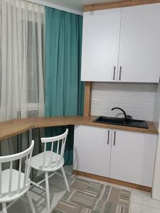 a kitchen with two chairs and a counter with a sink at Apartament in Ialoveni la 5 km de Chisinau in Ialoveni
