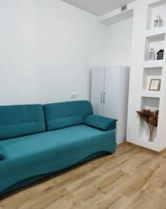niebieską kanapę w pokoju z drewnianą podłogą w obiekcie Apartament in Ialoveni la 5 km de Chisinau w mieście Ialoveni