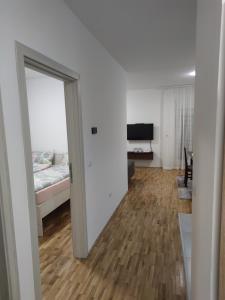 een woonkamer met een bed en een schuifdeur bij Apartman 022 in Smederevska Palanka