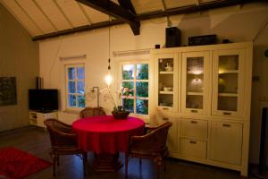 a dining room with a red table and chairs at Op de Smelen 1 - 43 m2 in Blitterswijck