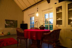 a dining room with a red table and chairs at Op de Smelen 1 - 43 m2 in Blitterswijck