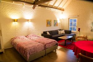1 dormitorio con 1 cama y 1 sofá en una habitación en Op de Smelen 1 - 43 m2, en Blitterswijck