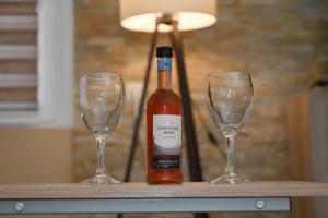 a bottle of wine and two wine glasses on a table at Golden Star Viktor in Zaječar