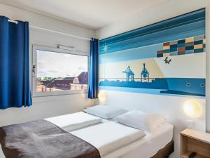 Schlafzimmer mit einem Bett und einem Fenster in der Unterkunft B&B Hotel Hamburg-Altona in Hamburg