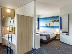 a bedroom with two beds and a ladder at B&B Hotel Hamburg-Altona in Hamburg