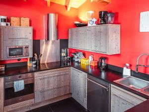 a kitchen with red walls and stainless steel appliances at Chalet Avoriaz, 6 pièces, 10 personnes - FR-1-314-161 in Morzine