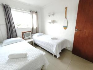 a hospital room with two beds and a window at Linda casa em ossos 70 m da praia in Búzios