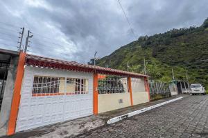budynek z pomarańczowymi i białymi drzwiami na ulicy w obiekcie Casita Linda Baños w Baños
