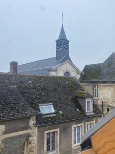 ein Gebäude mit einem Uhrturm darüber in der Unterkunft Appartement, cité médiévale in Laon