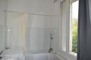 baño con bañera, lavabo y ventana en Appartement Montpellier (proche du centre), en Montpellier