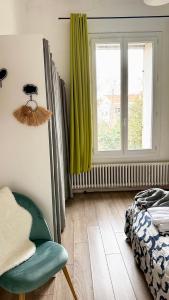 蒙佩利爾的住宿－Appartement Montpellier (proche du centre)，卧室配有床、椅子和窗户。