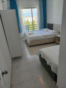 a bedroom with two beds and a window with a view at Emir Hotel Belek in Serik