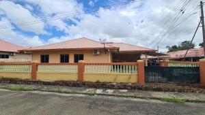a yellow house with a fence in front of it at Homestay 258 Beaufort in Beaufort