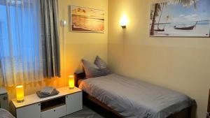 a bedroom with a bed and a desk with two lamps at FeWo, Monteurwohnung Pauline in Gorxheim
