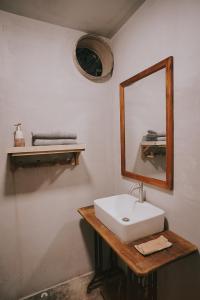 La salle de bains est pourvue d'un lavabo blanc et d'un miroir. dans l'établissement Thoai Mai House Phan Thiết, à Ấp Bình Hưng