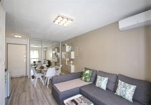 a living room with a couch and a table at Sol-y-Days Cyprianes appartement moderne avec piscine in La Grande-Motte