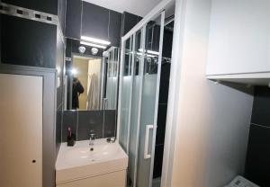 a bathroom with a sink and a mirror at Sol-y-Days Cyprianes appartement moderne avec piscine in La Grande-Motte
