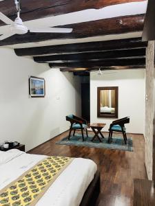 um quarto com 2 cadeiras, uma cama e um espelho em Main Street Inn em Srinagar