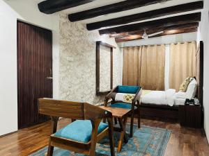 1 dormitorio con cama, mesa y banco en Main Street Inn, en Srinagar