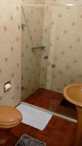 uma casa de banho com um chuveiro, um WC e um lavatório. em hostel MdeMarilia em Nova Friburgo