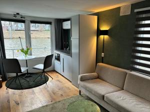 アムステルダムにあるLuxury studio on Robs houseboat special for couplesのリビングルーム(ソファ、テーブル付)