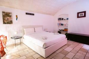 モルフェッタにあるA Stare - Stone Apartment in the Historic Center - Molfettaの白いベッドとテーブルのある寝室