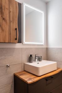 a bathroom with a white sink and a window at LOFT am See - dein Zuhause direkt am Wasser - self checkin - Bitcoin accepted in Thun