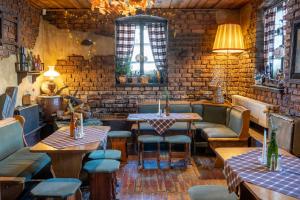 a restaurant with tables and chairs and a brick wall at Górski Sad - Pokoje in Piechowice