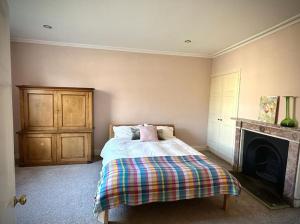 um quarto com uma cama e uma lareira em Large Georgian house in heart of Exeter em Exeter