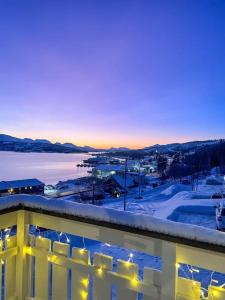 - une vue sur la ville dans la neige au coucher du soleil dans l'établissement Leilighet med god utsikt, à Tromsø
