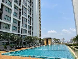 a swimming pool in front of a tall building at 1BR Apartment in Bangkok
