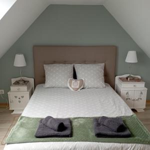 a bedroom with a bed with two towels on it at Cottage chaleureux à 25 mn de la côte de granit rose in Bégard