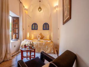 a bedroom with a bed and a table at Riad Maialou & SPA in Marrakesh