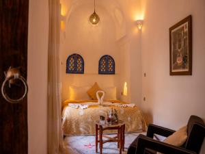 una camera con letto e tavolo di Riad Maialou & SPA a Marrakech