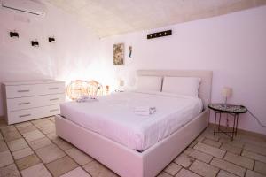 モルフェッタにあるA Stare - Stone Apartment in the Historic Center - Molfettaの白いベッドとテーブルのある白い寝室 +22枚の写真