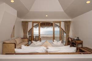 a living room with a bed and a view of the ocean at The Shore Agonda in Agonda