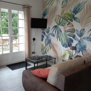 a living room with a couch and a plant wall at Cottage chaleureux à 25 mn de la côte de granit rose in Bégard