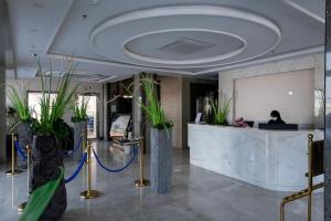 a lobby with potted plants and a reception desk at هوليداي بلس المروه- Holiday Plus Al Marwa in Jeddah