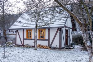 una pequeña casa con nieve en el techo en Górski Sad - Bazylia en Piechowice