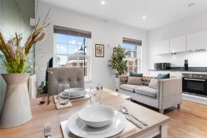 uma cozinha e sala de estar com mesa e cadeiras em Modern One Bedroom Flat - Near Heathrow, Windsor Castle, Thorpe Park - Staines London TW18 em Londres