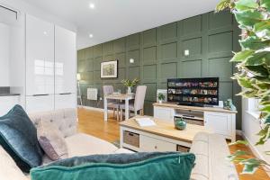 uma sala de estar com um sofá e uma televisão em Modern One Bedroom Flat - Near Heathrow, Windsor Castle, Thorpe Park - Staines London TW18 em Londres